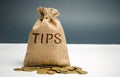 Money bag with the word Tips. Award for good service in the cafe / restaurant. A gratuity is a sum of money customarily given by a Royalty Free Stock Photo