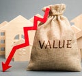 A money bag with the word Value, wooden houses and down arrow. The concept of reducing the market prices of real estate. Low price Royalty Free Stock Photo