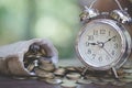 Money bags and  clock on wooden table with nature background,  Money savings,  Stacking growing coins, Saves money for the future Royalty Free Stock Photo