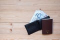 Money banknote in black wallet with Passport on wooden table, Top view and copy space. Time to Travel in Singapore concept Royalty Free Stock Photo