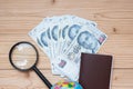 Money banknote with Passport, Magnifying glass, globe on wooden table, Top view and copy space. Time to Travel in Singapore Royalty Free Stock Photo