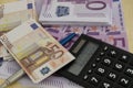 Many 500 and 50 euro bills with a pen and a calculator with a mi