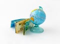 A money box made in the form of a globe, the planet Earth with a money slot at the top stands near a stack of Israeli banknotes of Royalty Free Stock Photo