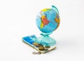 A money box made in the form of a globe, the planet Earth with a money slot at the top stands on a stack of Israeli banknotes of d Royalty Free Stock Photo