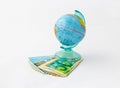 A money box made in the form of a globe, the planet Earth with a money slot at the top stands on a stack of Israeli banknotes of d Royalty Free Stock Photo