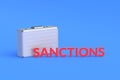 Money briefcase with word sanctions. Severe financial constraints