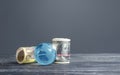 Money bundle rolls world currencies and a blue glass globe. Capital investment, savings. Profit income, dividends payouts.