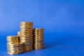 Money, Business and Saving  Concept. Closeup of stack of gold coins on blue background with copy space Royalty Free Stock Photo