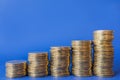 Money, Business and Saving  Concept. Closeup of three stack of gold coins on blue background with copy space Royalty Free Stock Photo