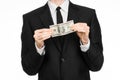 Money and business theme: a man in a black suit holding a bill of 100 dollars and features a hand gesture on an isolated white bac Royalty Free Stock Photo