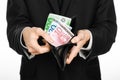 Money and business theme: a man in a black suit holding a purse with paper money Euro isolated on white background in studio Royalty Free Stock Photo