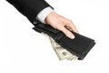 Money and business topic: hand in a black suit holding a wallet with dollar banknotes isolated on white background in studioMoney Royalty Free Stock Photo