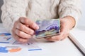 Money from Canada: Canadian Dollars. Old woman counting bills on table Royalty Free Stock Photo