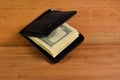 Money clip with one hundred dollars banknotes on wooden table Royalty Free Stock Photo