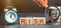 Money, clock and wooden blocks with the word Risk. The concept of financial risk. Justified risks. Investing in a business project