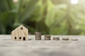 Money Coins arranged in graph neatly stack and there is a small wooden house Royalty Free Stock Photo