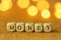 Money concept. Inscription money wooden letters on a gold glitter background with shining bokeh.Finance and business