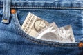 US dollar and condom in front pocket of blue jeans Royalty Free Stock Photo