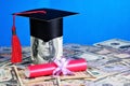 Money for education. Red diploma of the excellent student and academic cap of the student