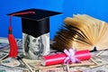 Money for education. Red diploma of the excellent student and academic cap of the student.