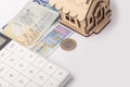 money, euro, wooden toy house, white calculator. the concept of buying and maintaining a house, apartment Royalty Free Stock Photo