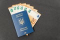 Money euros cash and Ukrainian Biometric passport. Concept monetary compensation or cash payments to Ukrainians. Travel Royalty Free Stock Photo