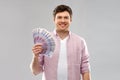 Smiling young man with fan of euro money over grey Royalty Free Stock Photo