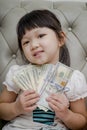 Money, finances and people concept - smiling little girl looking at dollar cash money Royalty Free Stock Photo