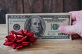 Money gift, big stack of money with red bow on wooden background Royalty Free Stock Photo