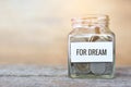 Money in a glass jar with `dream` word. concept