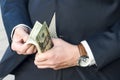 Money in the hands of a businessman close-up. a man in a business suit counts American dollars. cash payment. repay debts. financi Royalty Free Stock Photo