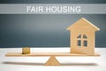 Money and house on the scales with the inscription Fair housing. Home appraisal. Property valuation. Housing evaluator. Fair trade Royalty Free Stock Photo