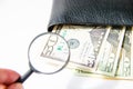 Money, hundred american dollars under a magnifying glass in black leather purse on white background Royalty Free Stock Photo