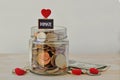 Money jar full of coins with Donate label and hearts - Charity concept