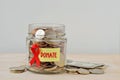 Money jar full of coins with red ribbon and Donate label - Aids charity and research fund concept Royalty Free Stock Photo