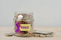 Money jar full of coins with violet ribbon and Donate label - Concept of Alzheimer, Pancreatic cancer, Epilepsy , Hodgkin`s