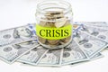 Money and a jar with the words `crisis`. Financial concept.