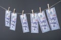 Close-up of money, dried on the ropes, fastened with clothespins. The concept of drying money. On a gray background Money