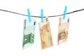 Money laundering. Euro banknotes hanging on clothesline against white background Royalty Free Stock Photo