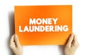 Money Laundering is the process of concealing the origin of money, obtained from illicit activities, text concept on card