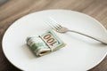 Money lying on the plate with fork. Dollars photo. Greedy corruption concept. Bribe idea