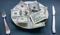 Money lying on the plate with fork and knife. Dollars photo. Greedy corruption concept. Bribe idea