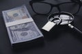 A money, magnifying glass, glasses and padlock on a black background