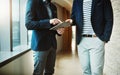 Money making mobile apps. two businessmen using a digital tablet together in a modern office. Royalty Free Stock Photo