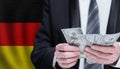 Money in male hands on German flag background. Banking, business, investment, corruption and social problems in Germany concept Royalty Free Stock Photo