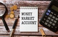 MONEY MARKET ACCOUNT written on paper with office tools and keyboard on grey background