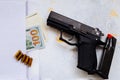 Money for murder. Black gun on American dollars background. Military industry, war, global arms trade, weapon sale, contract Royalty Free Stock Photo