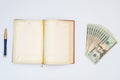 Money, notebook and pen with white background. Isolated Royalty Free Stock Photo