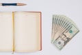 Money, notebook and pen with white background. Isolated Royalty Free Stock Photo