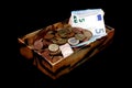 Money in an old box, banknotes and coins, isolated on black Royalty Free Stock Photo
